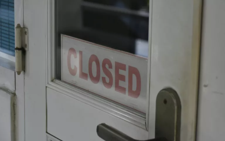 weiße Tür mit Closed Schild im Glasfenster