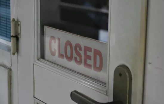 weiße Tür mit Closed Schild im Glasfenster