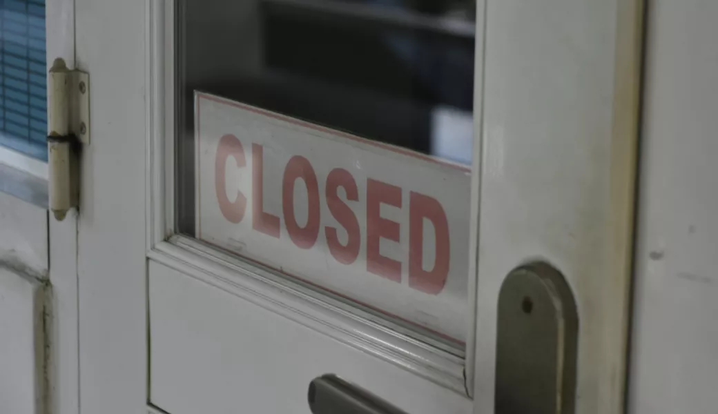 weiße Tür mit Closed Schild im Glasfenster